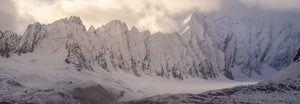 Snow covered mountains with sunlit clouds above